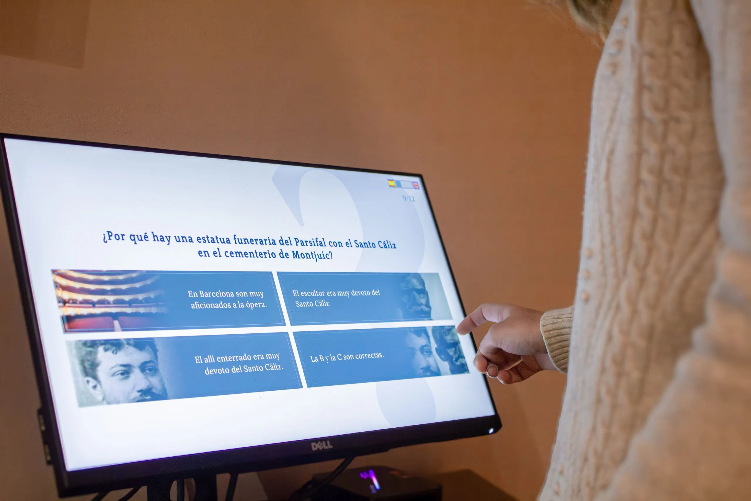 santo_caliz4 Vista de primer plano de un usuario respondiendo una pregunta de opción múltiple en una pantalla interactiva durante la visita museística del Santo Cáliz