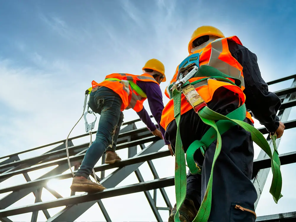 Dos trabajadores realizando trabajos en alturas en un andamio